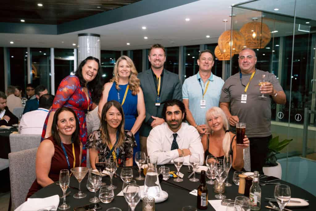 Group of professionals at Gold Coast Live event, discussing market insights.